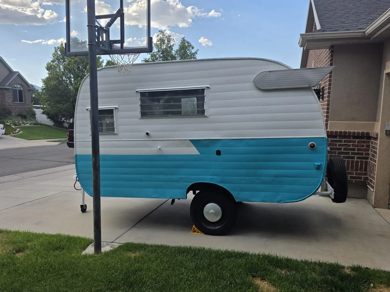 Teal-and-white trailer in side profile.