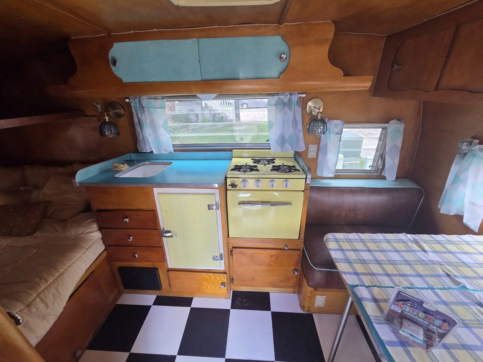 Yellow stove and teal counters above the checkerboard floor.