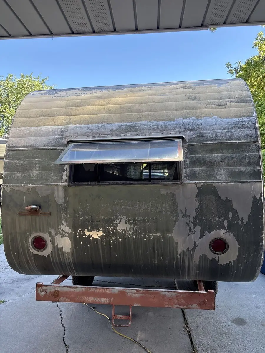 Original rear exterior with worn siding and lights.