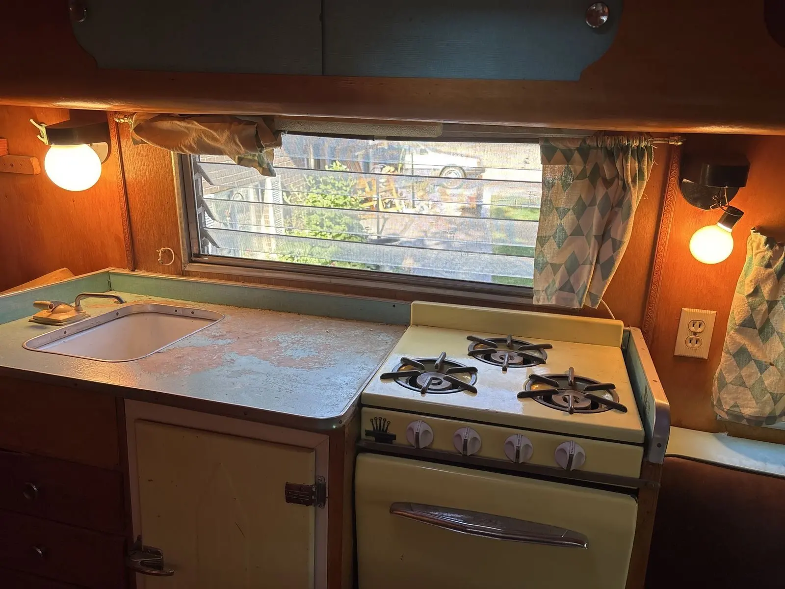 Original galley with its yellow stove and worn counter.