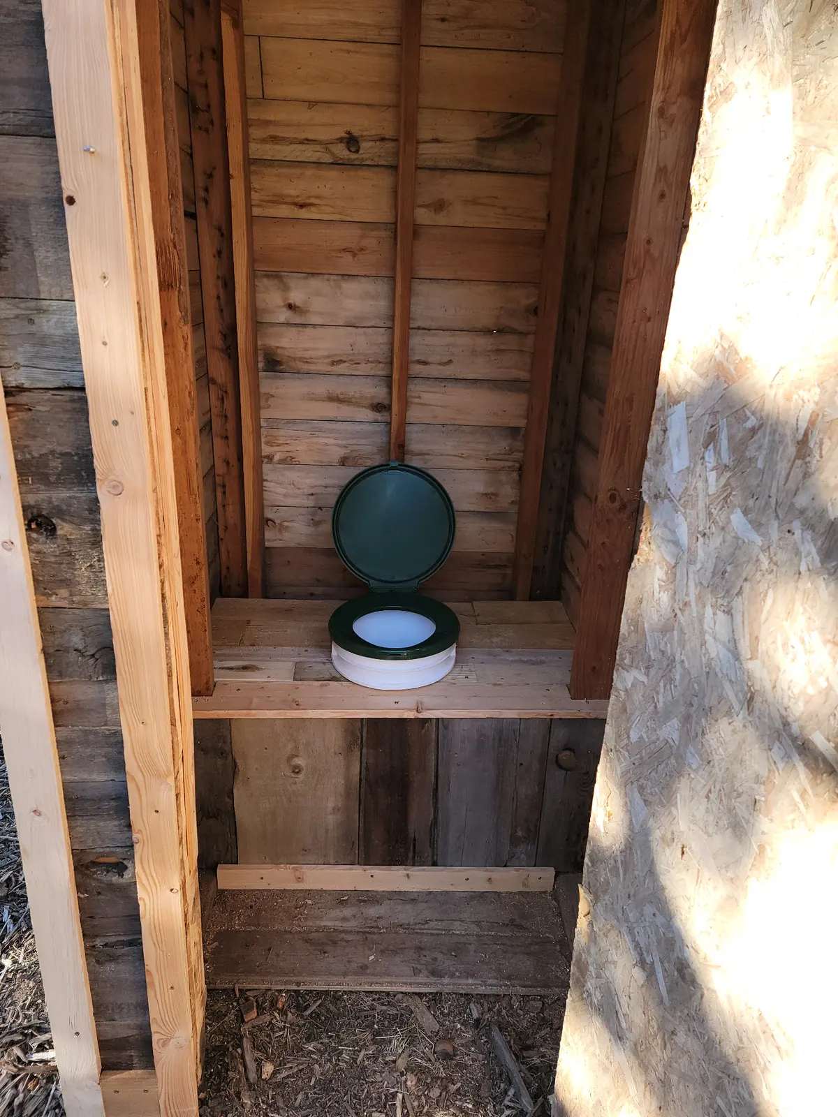 Rustic outhouse interior with composting toilet