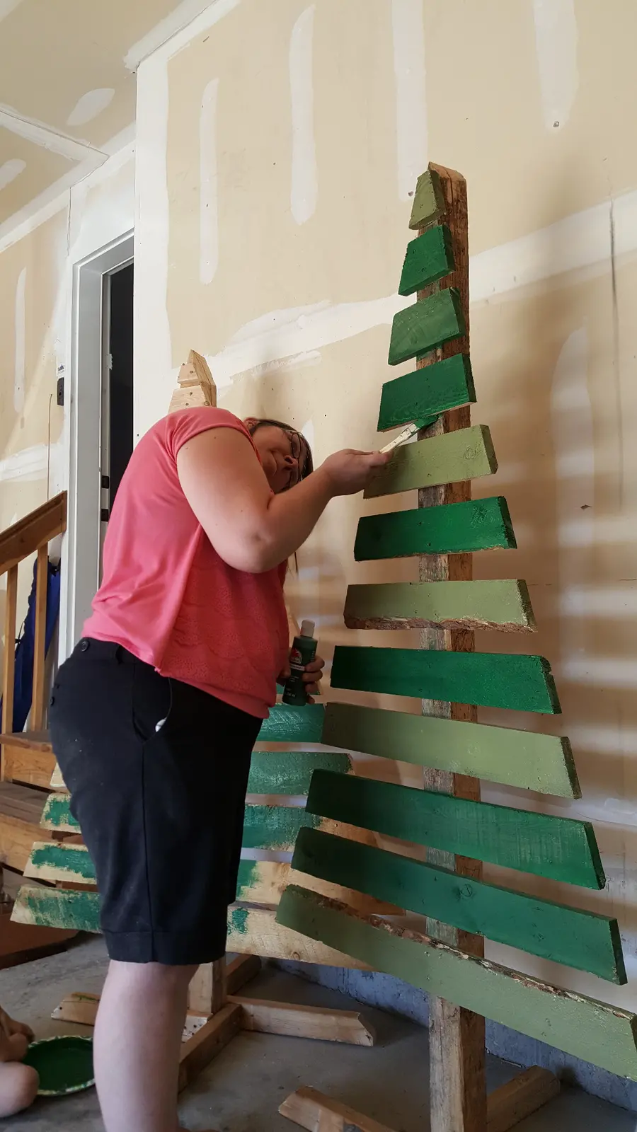 Painting the upper slats of a wooden Christmas tree.