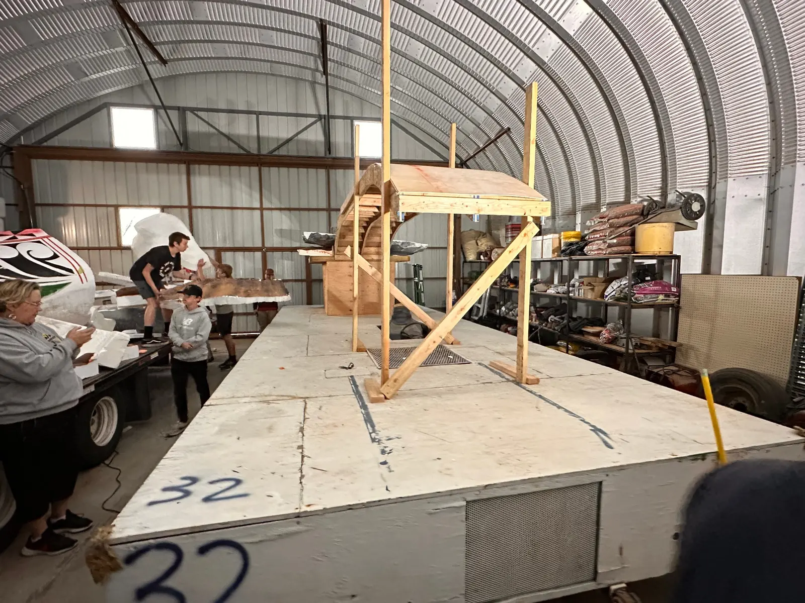 Parade float construction with wooden platform and arched structure