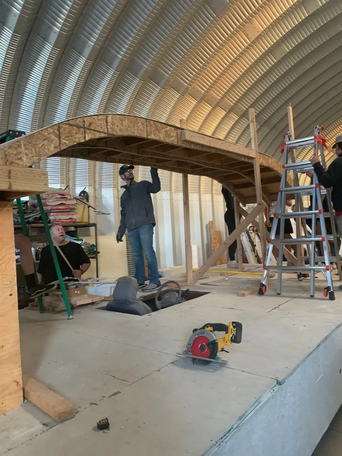 Parade float framing construction inside workshop with arched wooden beams