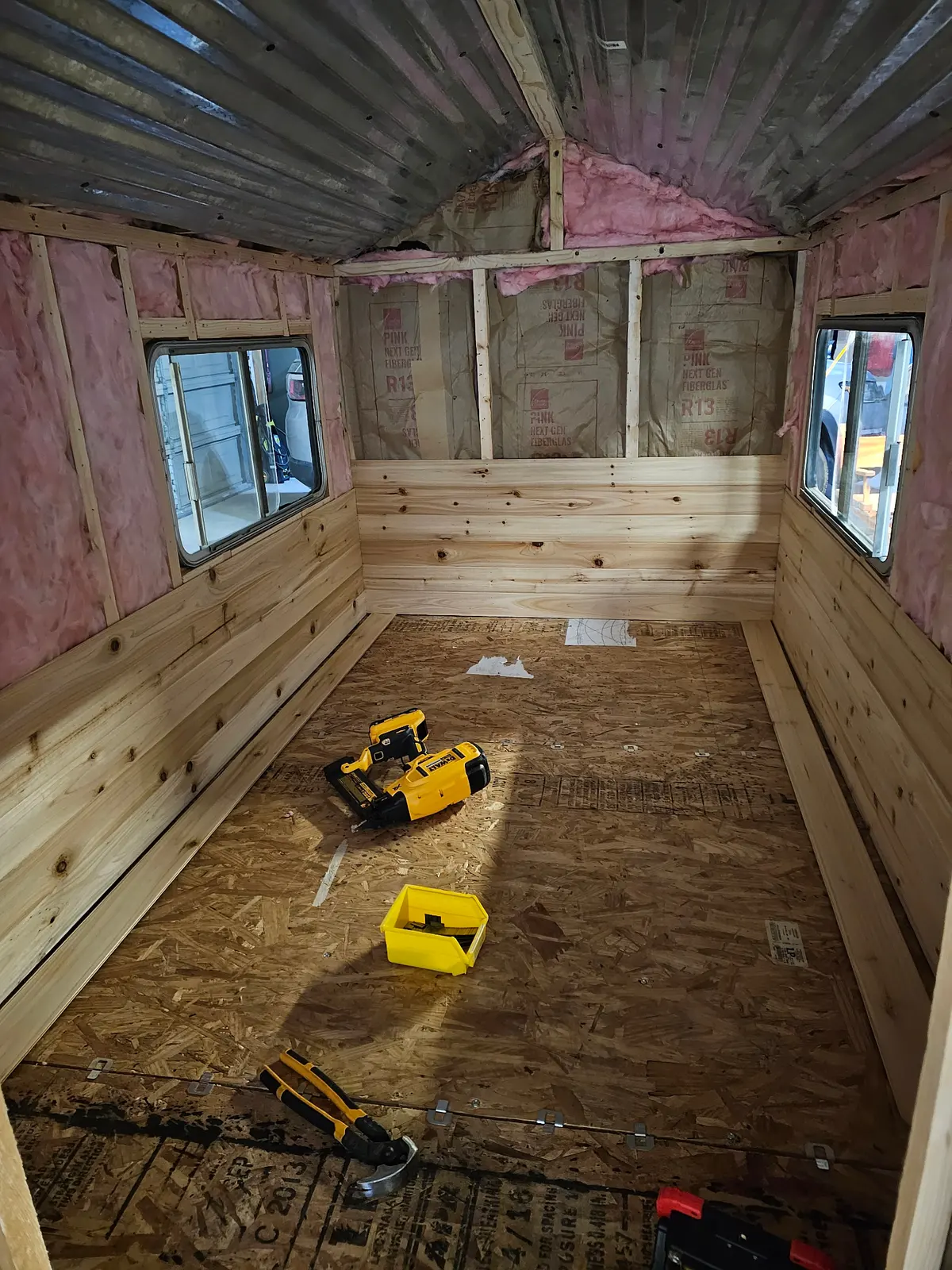 Interior construction with pink insulation and wooden benches