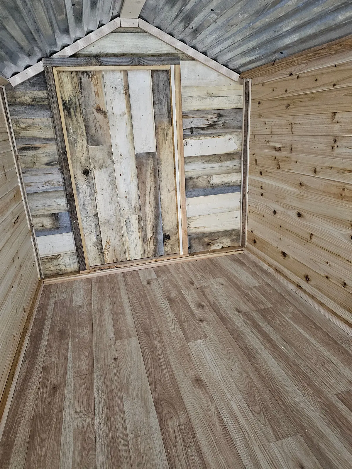 Interior finished view with reclaimed wood door and pine walls