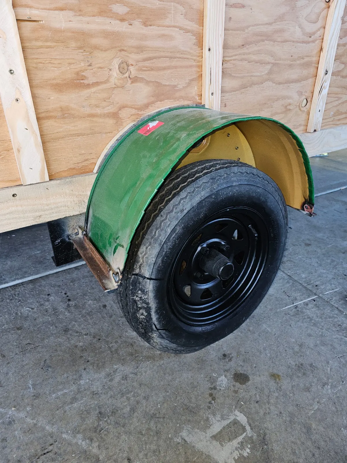 Cabin trailer wheel detail with vintage green fender
