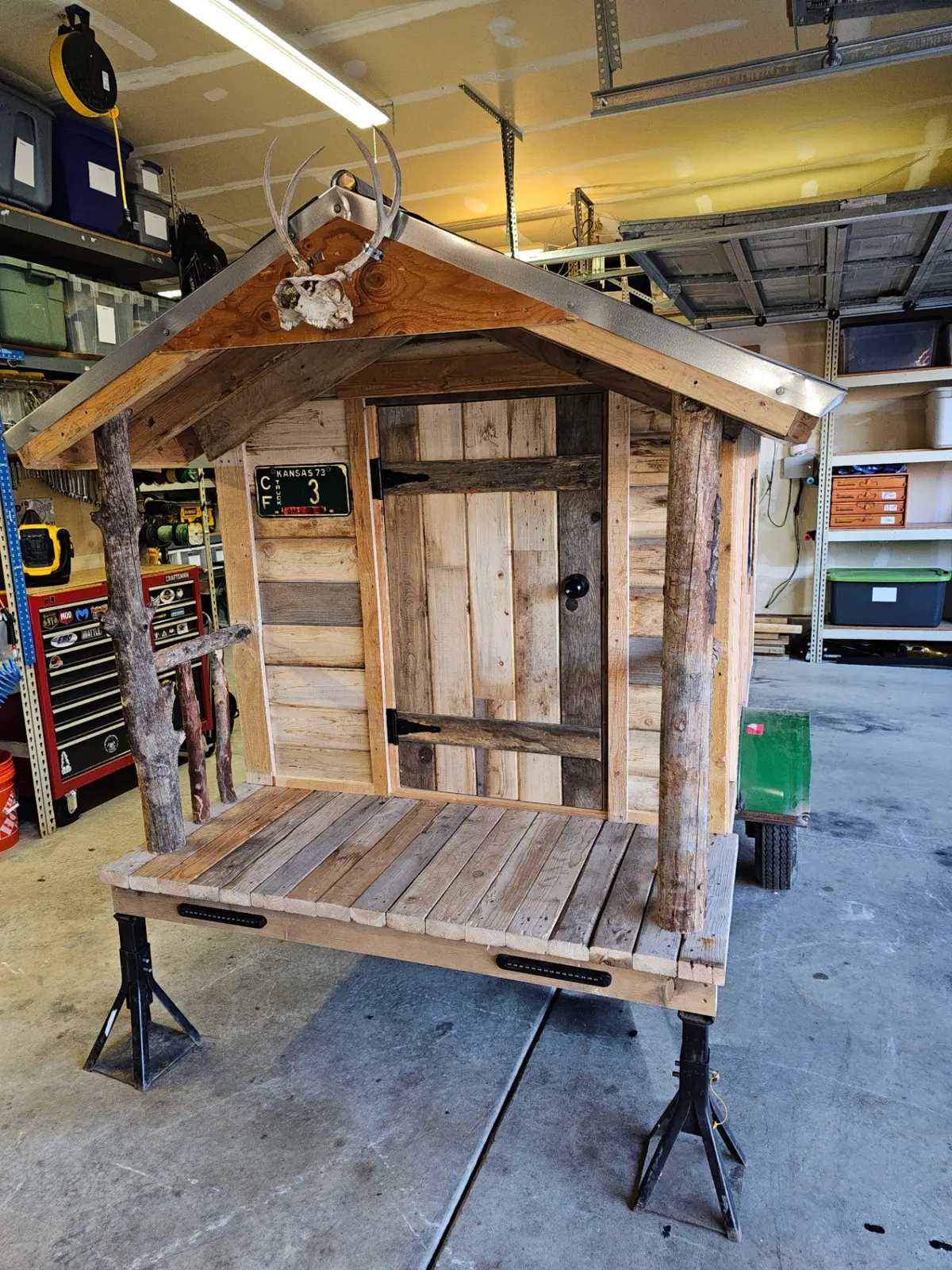 Cabin trailer front entrance with rustic door and antler decoration