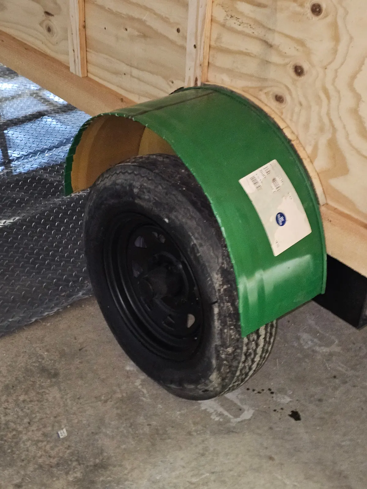 Green fender wheel well component with tire