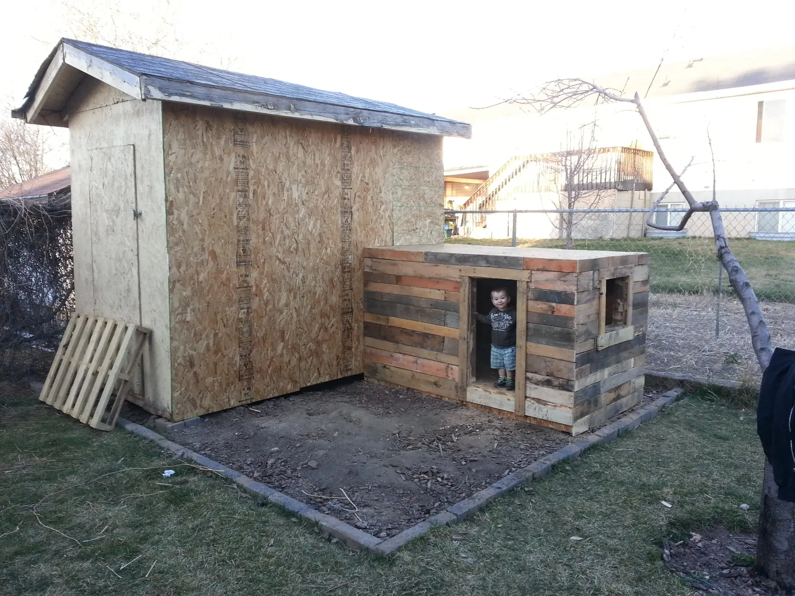 Western pallet playhouse construction - child at entrance