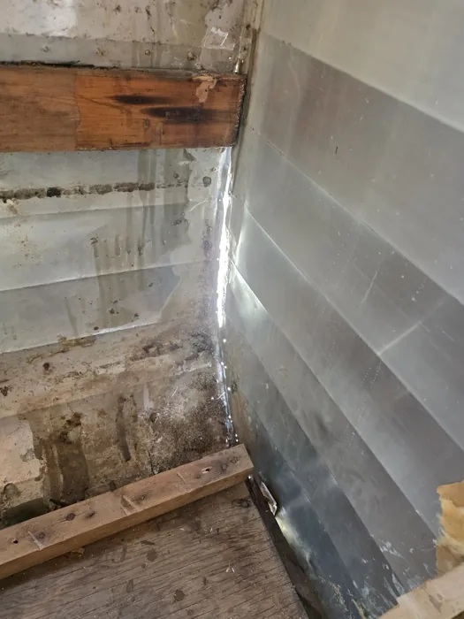 Opened interior wall with the framing and outer metal skin exposed.