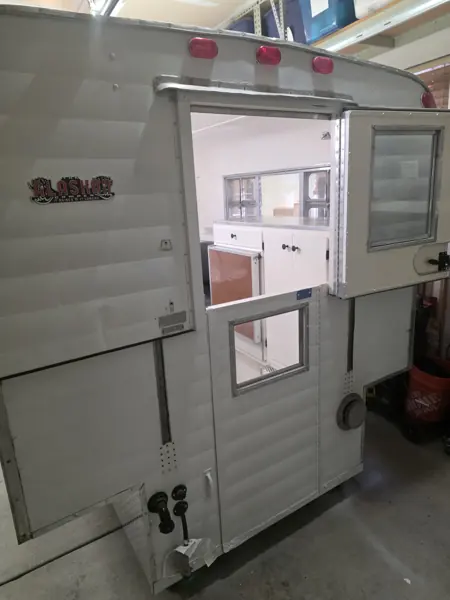 Refinished Alaskan camper entrance with the custom 3D-printed Alaskan Camper decal beside the open door