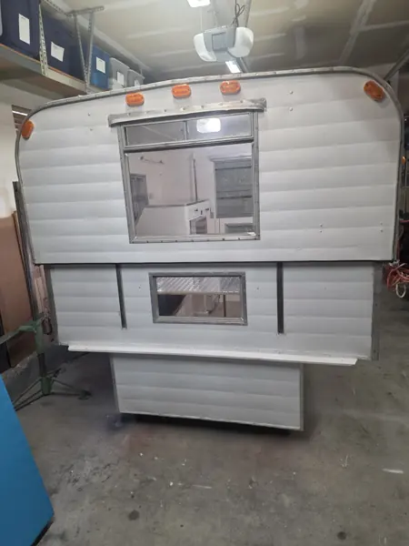 Full rear exterior of the Alaskan camper after restoration, with the entrance door closed