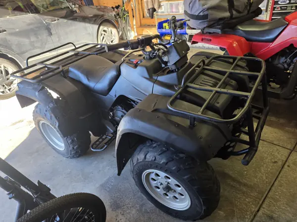 ATV reassembled with dark body panels, seat and cargo racks before the snowplow is attached