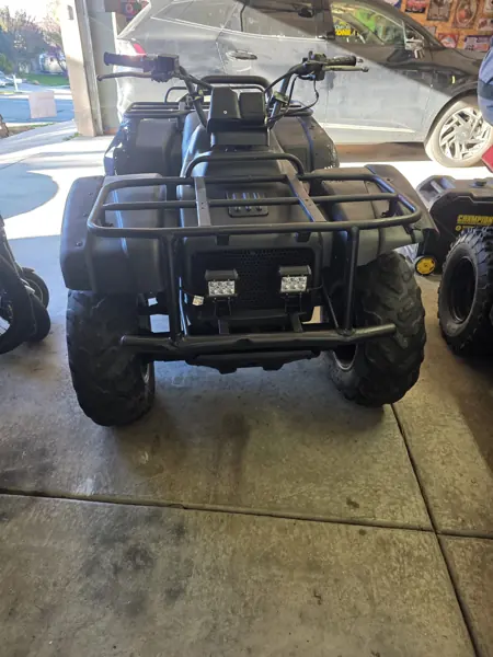 Front view of the reassembled ATV showing the cargo rack and two front lights before plow attachment