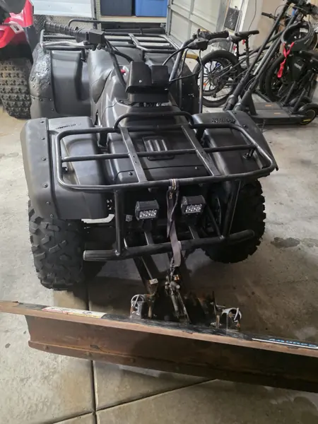 Front view of the reassembled ATV with cargo rack, front lights and snowplow