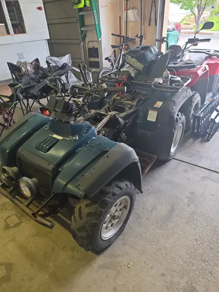 ATV before restoration with worn green bodywork, missing seat and exposed center section