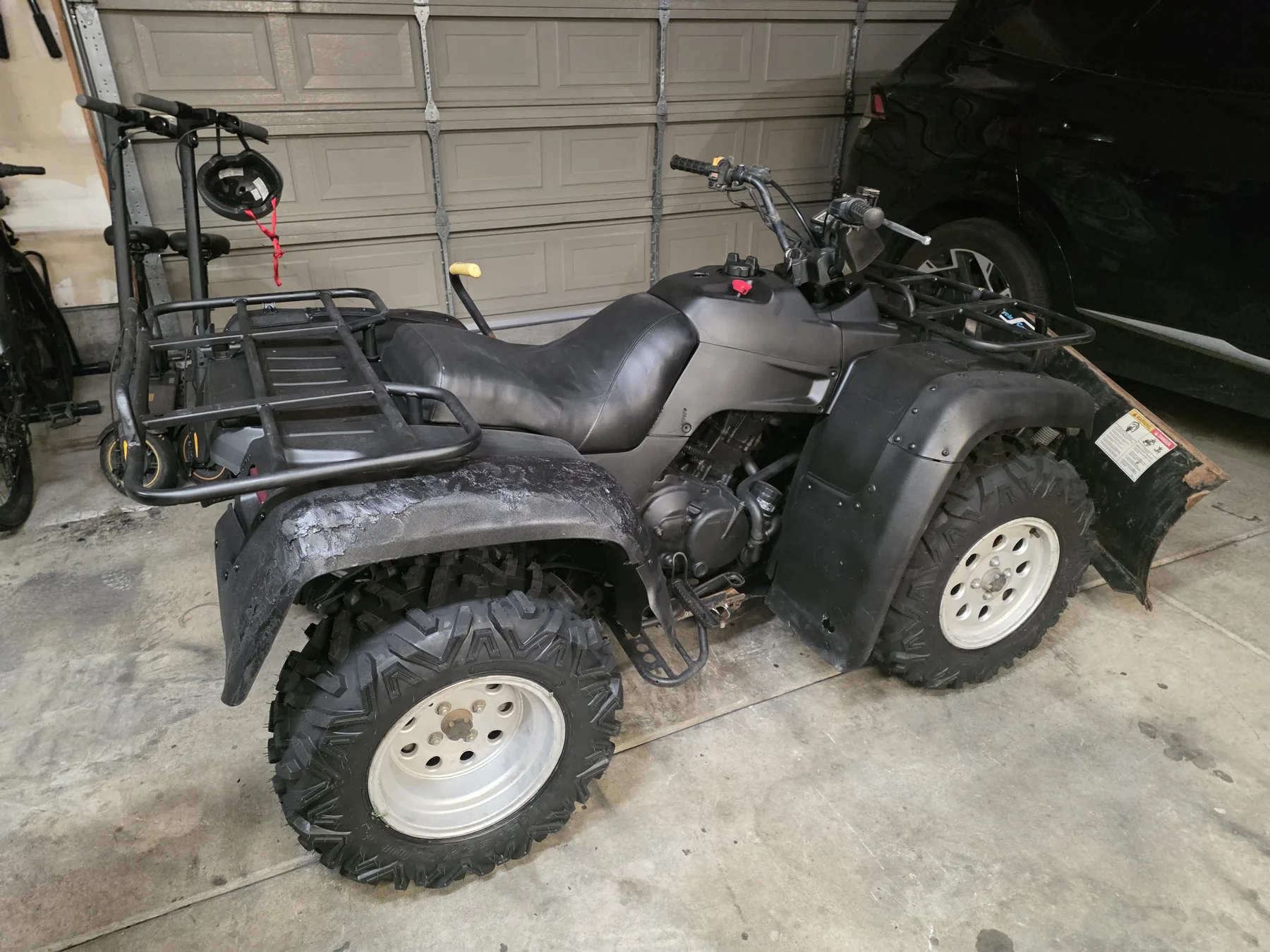 ATV during reassembly, with repaired dark bodywork and cargo racks.