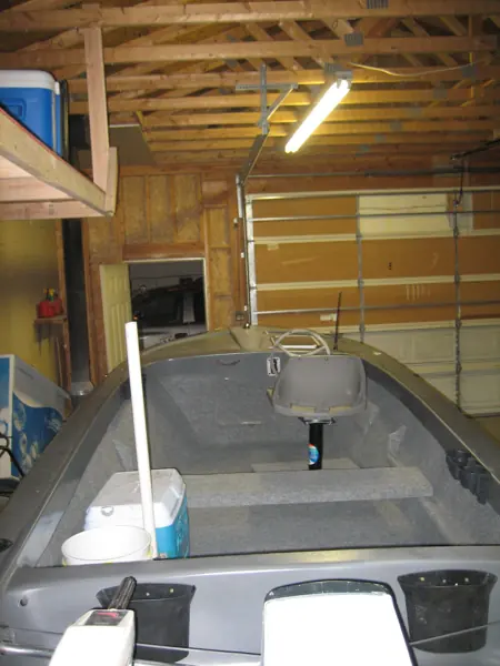 Restored boat interior viewed forward from the stern, showing gray carpeting, seating and steering position