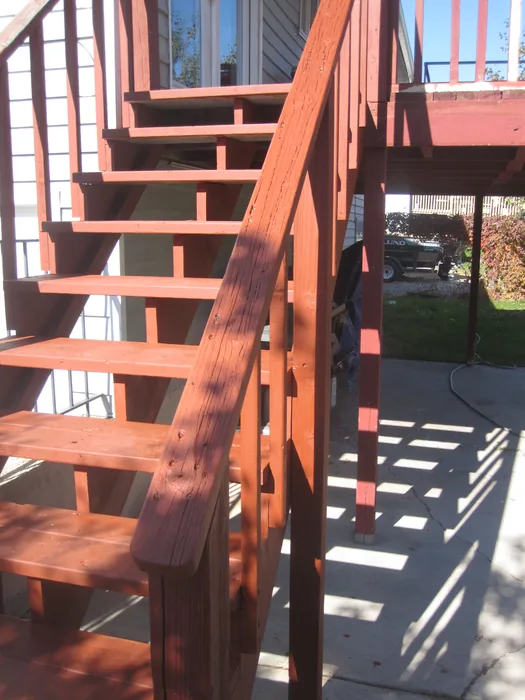 Wooden stairway and railings leading up to the covered deck.