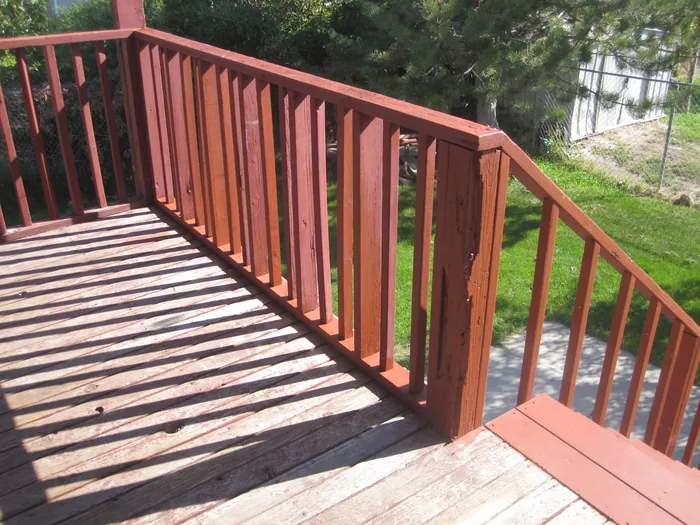 View across the deck boards and wooden railing toward the stairs.