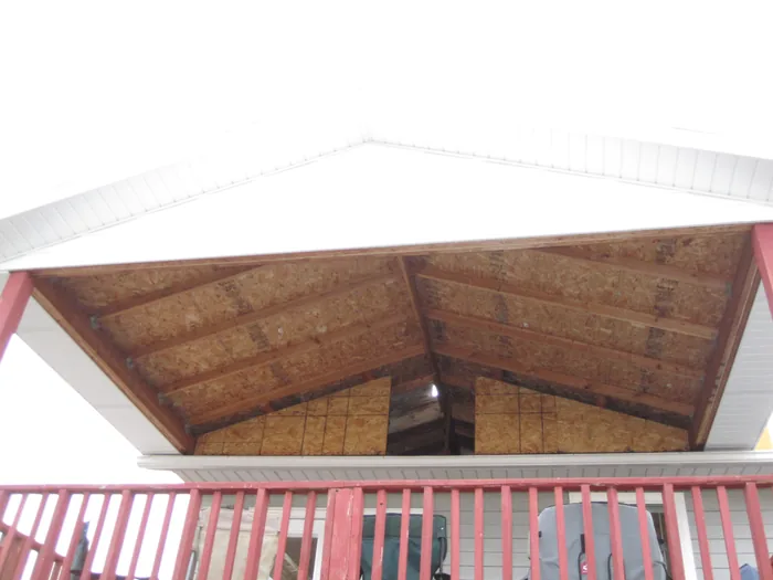 Underside of the deck roof showing its wooden sheathing and beams.