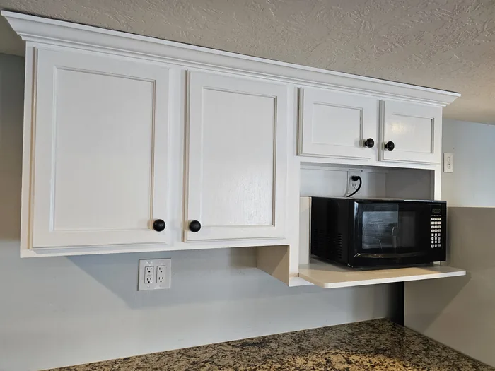 Finished wall cabinets and built-in microwave shelf.