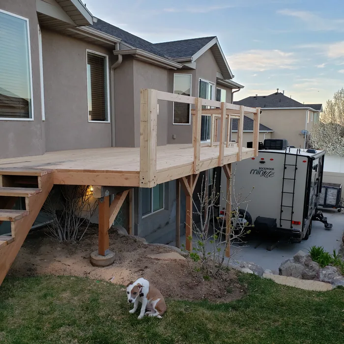 Deck platform and stairs with railing construction underway.
