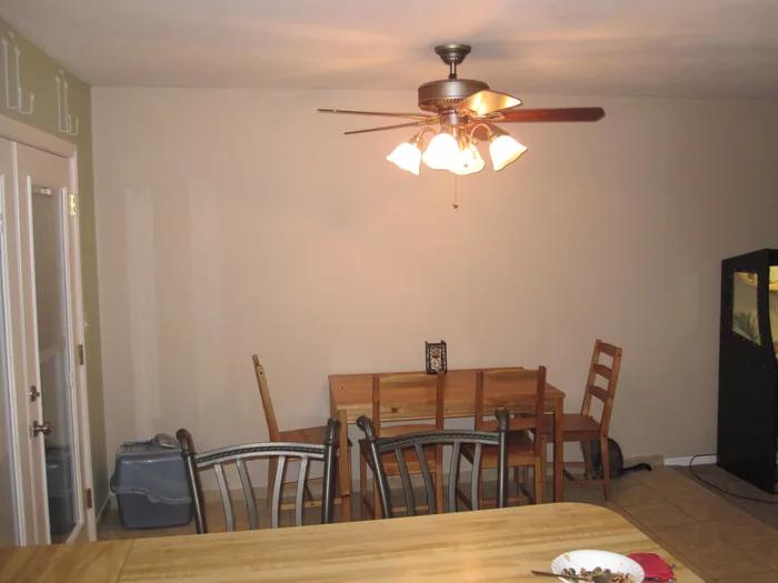Finished dining area beside the kitchen, with neutral walls and a ceiling fan.
