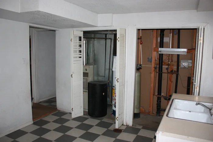 Basement kitchen before renovation, showing open wall sections and the older room layout.