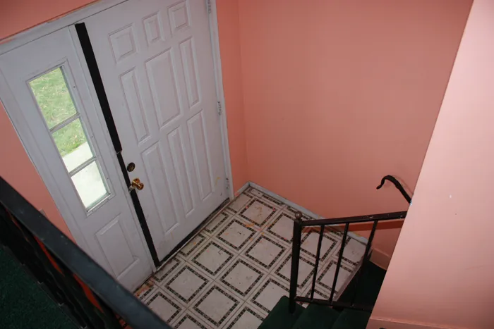 Stair entry before renovation, with pink walls and the older floor finish.