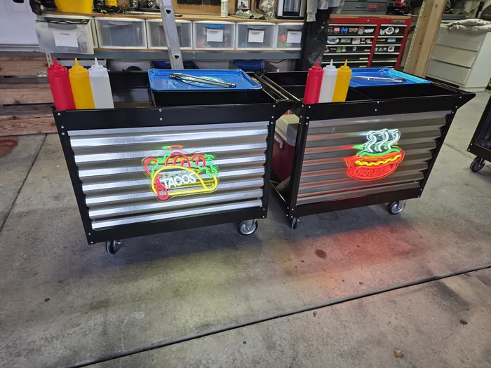 Two later completed carts with horizontal metal panels and illuminated food signs.