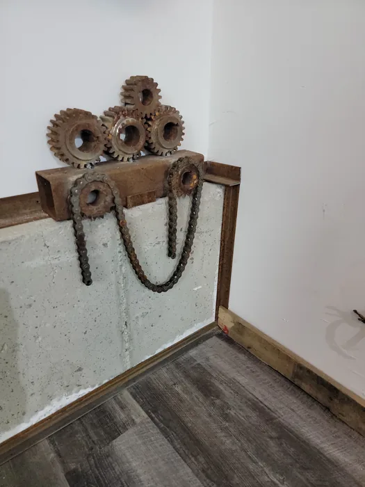 Decorative wall-mounted gears and hanging chains in the office.