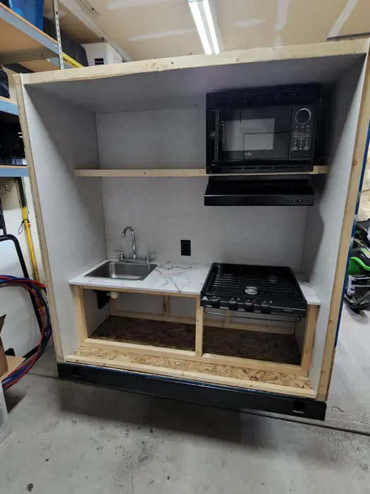 Rear kitchen with the sink, stove and microwave installed.
