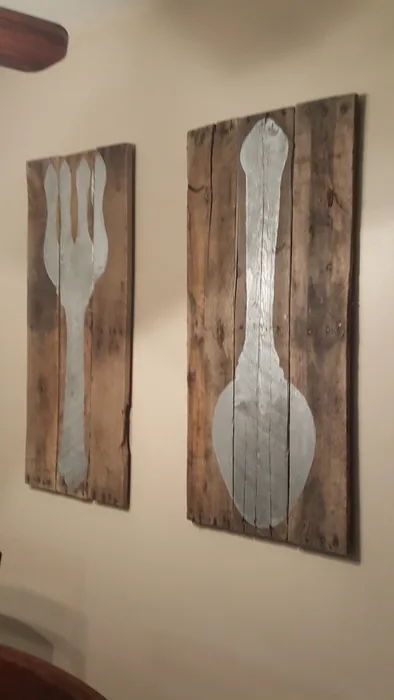 Pair of wooden wall panels with large white fork and spoon designs.