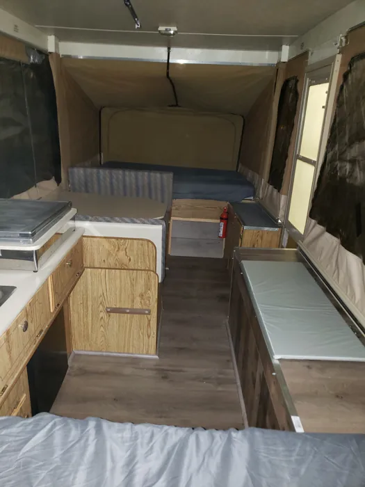 Finished interior viewed across the sleeping area toward the galley and seating.