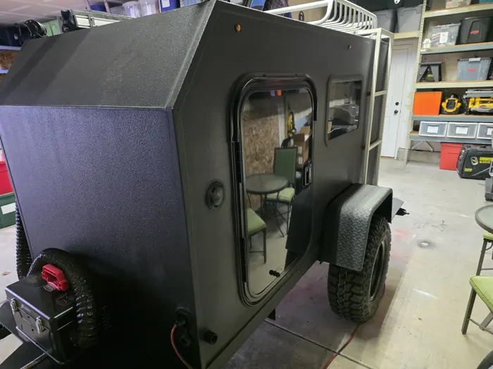 Front three-quarter view of the compact trailer and its curved front wall.