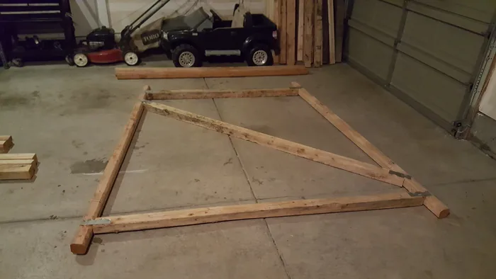 Large wooden frame assembled flat on the workshop floor.