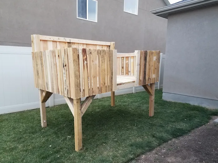 Elevated fort platform with wooden walls and railings taking shape.