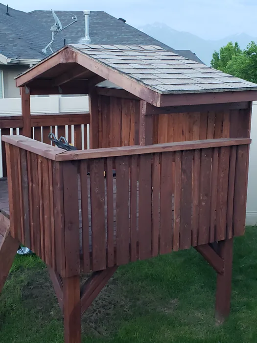 Side view of the wooden fort with its completed shingled roof.